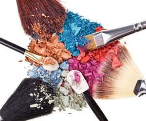 Composition with makeup brushes and broken multicolor eye shadows